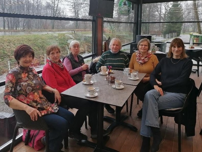 Člani UTŽO sedijo za mizo med pavzo za kavo.