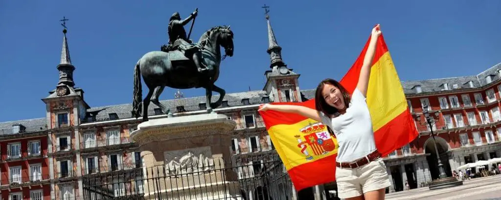 Mladenka razpira špansko zastavo na madridskem trgu.